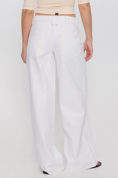 Rear studio view from the waist down showing the back patch pockets, white logo waistband patch, and wide-leg cut of bright white low-rise jeans.