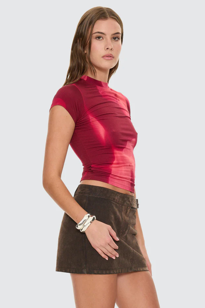 A side profile studio view on a model, showcasing the clean, body-conforming drape of the stretch fabrication and the snug fit of the short cap sleeves.