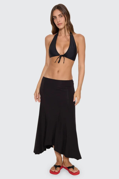 Back view of model wearing the Thrills Sienna Midi Skirt in Black with red platform sandals, showing the smooth waistband and midi length.