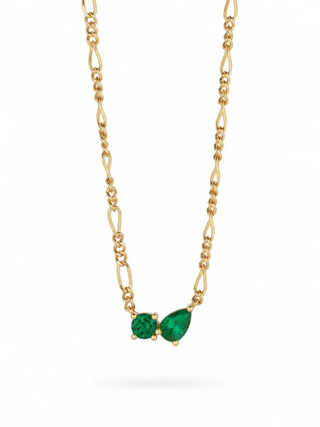 Clean product shot of the 18k gold-plated Twin Flame Necklace on a fine figaro chain featuring a side-by-side brilliant-cut and pear-cut green cubic zirconia crystal pendant.