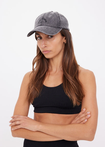 Shop the Cosmic washed black denim cap featuring a soft retro fit and minimalist embroidered horseshoe logo. A versatile, vintage-inspired staple with an adjustable back strap for the perfect casual look.