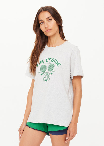 The Upside Racquet Casey Tee in grey marle. Featuring a vintage-inspired "Making a Racquet" logo in British Racing Green, this regular-fit organic cotton jersey tee offers sustainable, modern comfort.