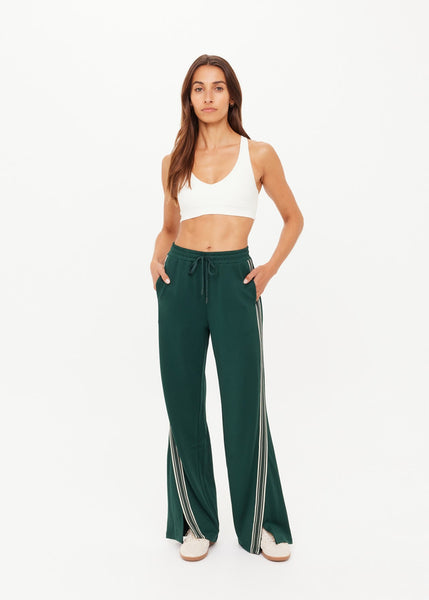 High-waisted Roma track pants in British racing green featuring cream contrast tape stripes along the side seams and an elasticated waistband.