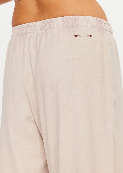 Close-up rear view focusing on the waistband and signature embroidered plum arrow logo.