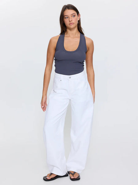 Full-length studio shot of a model wearing Thrills Sloane Low Rise Barrel Jeans in Whiteout, styled with a charcoal grey tank top and black leather sandals.