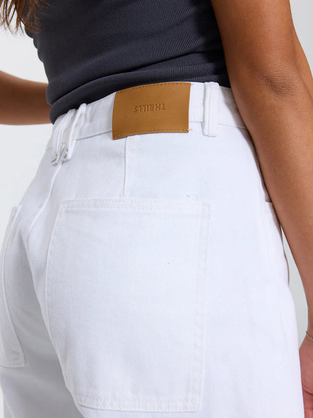 Close-up rear detail shot showing the back waistband, patch pocket, and tan leather logo patch of the Thrills Sloane Low Rise Barrel Jeans in Whiteout.