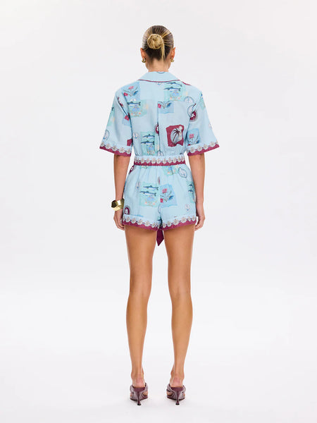 Full back view of the Sintra Playsuit in Blue, illustrating the clean shoulder yoke and the consistent embroidered detailing across the rear hem.