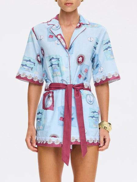 Detailed shot of the scalloped hemline of the playsuit shorts, showcasing the complex floral broderie anglaise patterns.