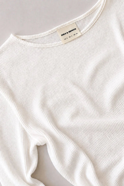 Close-up shot of the white ribbed hemp-cotton jersey top, showing the bound crew neckline construction and inner size label.