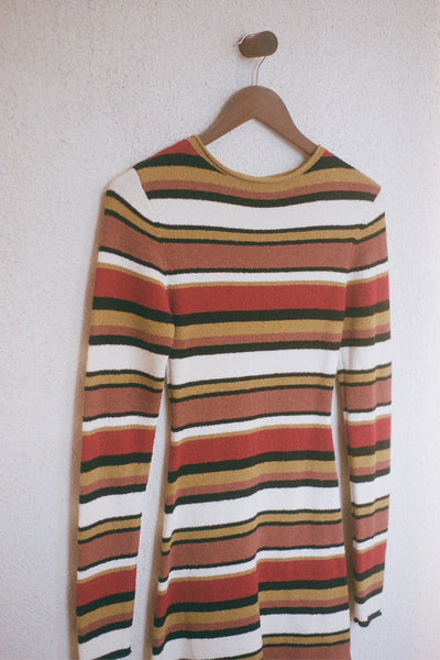 A contemporary high-neck knit dress in a warm, autumnal stripe palette, combining a retro-inspired aesthetic with a soft, modern bouclé finish.