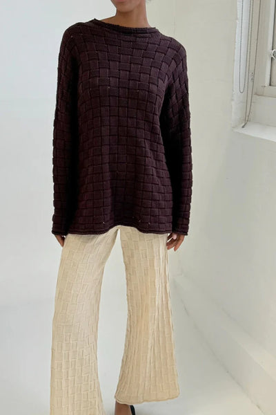 A side profile view from the shoulder down, accentuating the loose-cut armholes, easy-layering sleeve width, and the thick, premium hand feel of the heavy yarn.