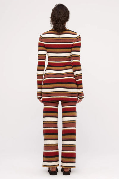 A contemporary high-neck knit dress in a warm, autumnal stripe palette, combining a retro-inspired aesthetic with a soft, modern bouclé finish.
