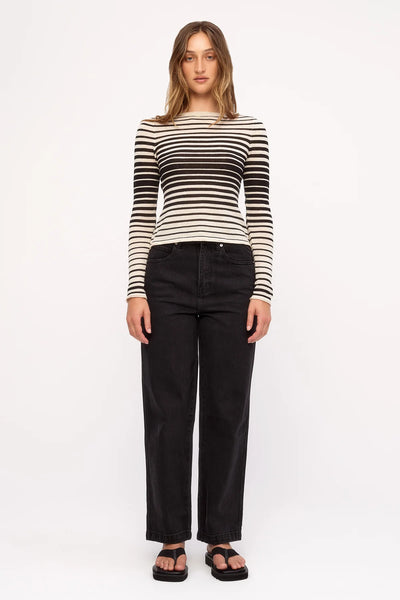 Front view studio shot of a model wearing the fitted Zulu & Zephyr Ramie Cotton Knit Top in Ombre Stripe and black straight-leg jeans.