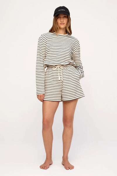 Three-quarter studio portrait highlighting the elasticated waistband, side pockets, and cream drawcord on the Zulu & Zephyr Jersey Sport Short in Black Stripe.