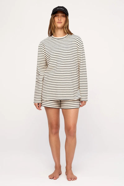 Front view studio photo of a model featuring the crewneck Zulu & Zephyr Jersey Long Sleeve Top in Black Stripe styled with matching shorts.