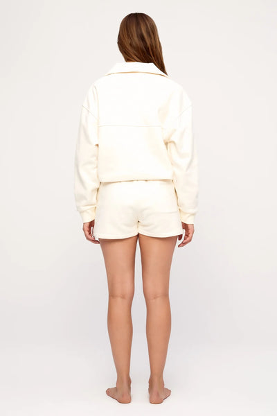 Rear studio view of a model wearing the Zulu & Zephyr Sport Sweat Shirt Fleece in Cream paired with matching cream sweat shorts.