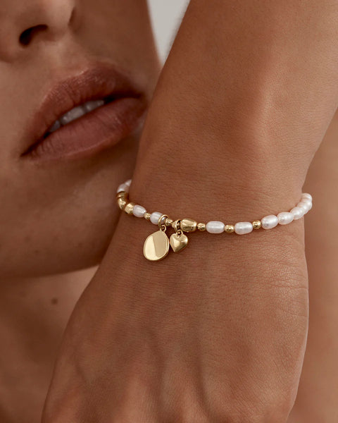 Features an engravable coin and heart charm.