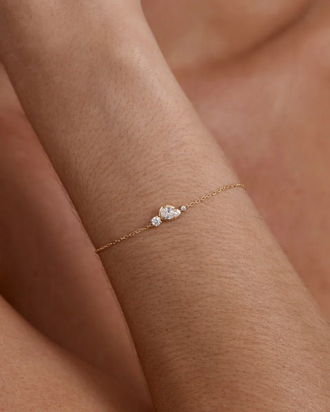 On-model shot featuring the delicate diamond-cut chain and central cubic zirconia pendant of the By Charlotte Quiet Radiance Bracelet.