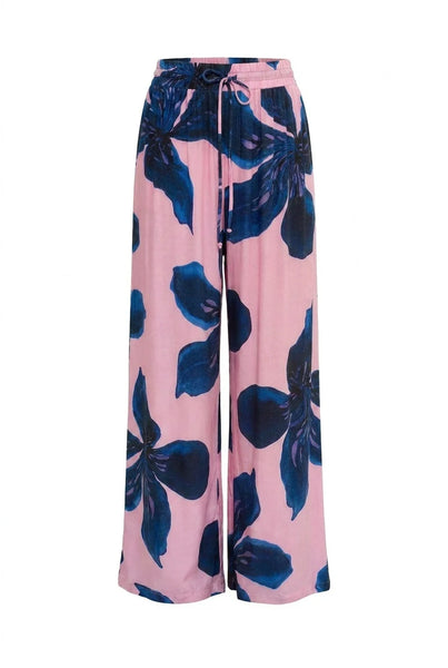 Flat lay product view of the Summi Summi Wide Leg Pant in Sway print, featuring a pink fabric with large blue floral motifs, an elasticated waistband, and an adjustable drawstring tie.