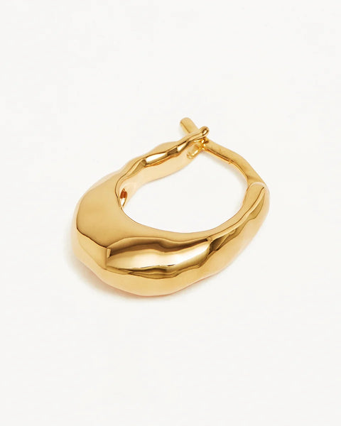 A polished gold abstract hoop earring with a wavy, organic silhouette and a small top clasp, shown on a clean white background.