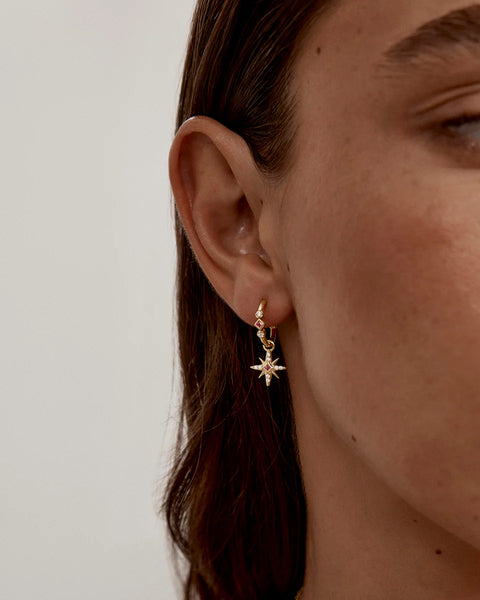 18k gold vermeil celestial hoop earrings with lab-grown pink sapphires and cubic zirconia. Dreamy star charms for a polished look.
