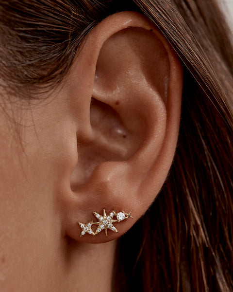 18k gold vermeil ear crawlers with crystal-encrusted moon and star motifs. Features a polished finish and elegant mirrored design.