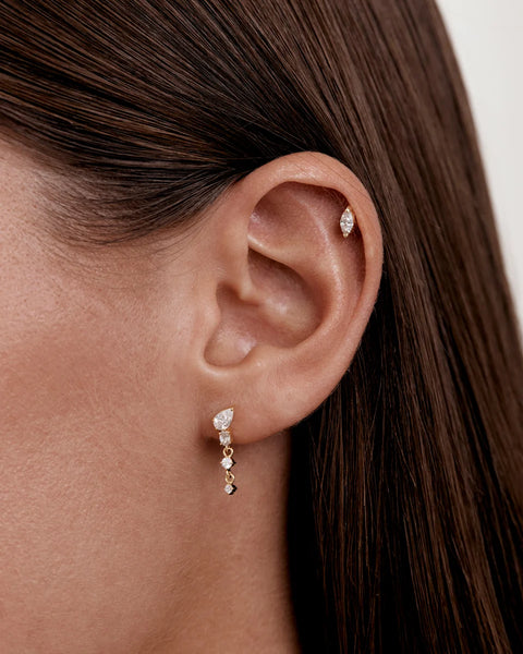 On-model shot of the By Charlotte Guided by the Stars drop earring worn in a lobe piercing, styled with a small marquise stud in the helix.