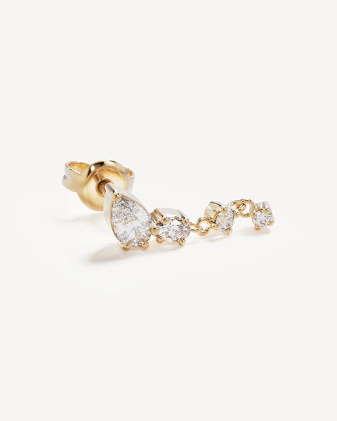 Single 18k gold vermeil Guided by the Stars drop earring featuring pear, oval, and round cubic zirconia stones on a studio background.
