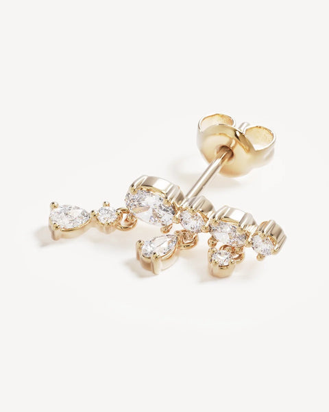 Close-up product detail of a single By Charlotte Cosmic Whisper Ear Crawler in 18k gold vermeil, featuring cluster-set cubic zirconias with small pear-cut dangles.