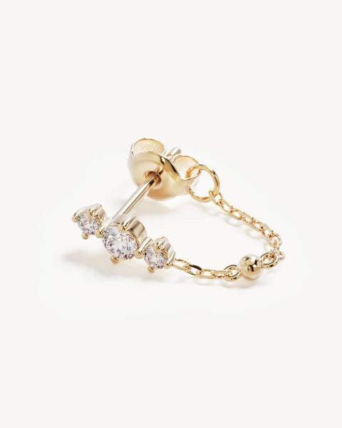 Macro product view of a single By Charlotte In the Stars Chain Huggie Earring in 18k gold vermeil, highlighting the round-cut cubic zirconia stud trio and fine chain attachment