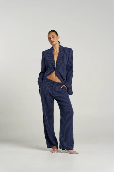 Full-length studio shot of model posing in the Summi Summi OS Blazer in Navy Pinstripe paired with the matching Boss Pant and pointed heels.