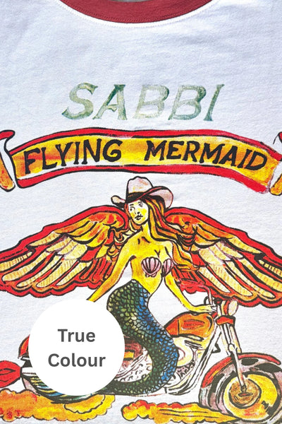 Close-up detail of the vintage-washed graphic on the Sabbi The Very Oversized Flying Mermaid Tee in White, highlighting the hand-designed flying mermaid artwork and red contrast collar.