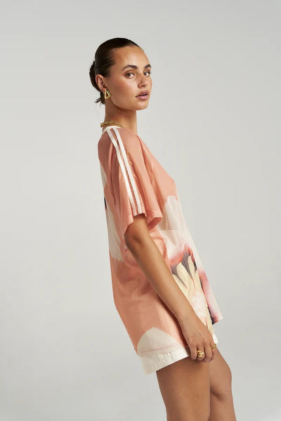 Side profile view of a model wearing the short-sleeve Summi Summi Harlequin Tee, highlighting the white stripe details along the shoulders and sleeves.