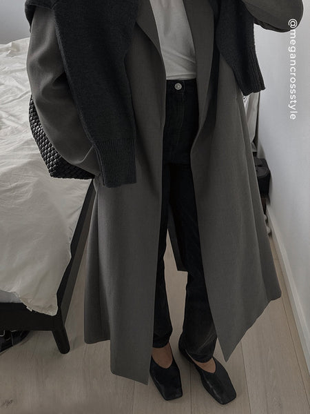Top-down view of model wearing Senso Brynn ebony leather high-cut flats, styled with black jeans, a white tee, a dark grey trench coat, and an over-the-shoulder sweater.
