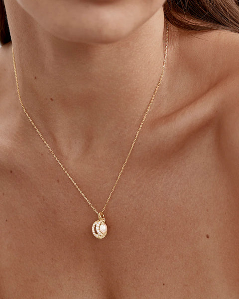 18k gold plated necklace featuring a crystal moon, sun, and freshwater baroque pearl. Includes an adjustable slider and diamond cut chain.
