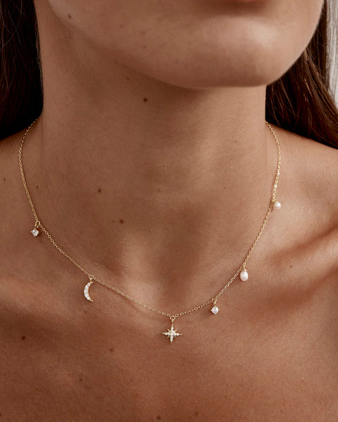 18k gold vermeil choker featuring moon and star charms, freshwater pearls, and cubic zirconia. Includes an adjustable slider for a custom fit.