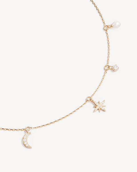 18k gold vermeil choker featuring moon and star charms, freshwater pearls, and cubic zirconia. Includes an adjustable slider for a custom fit.
