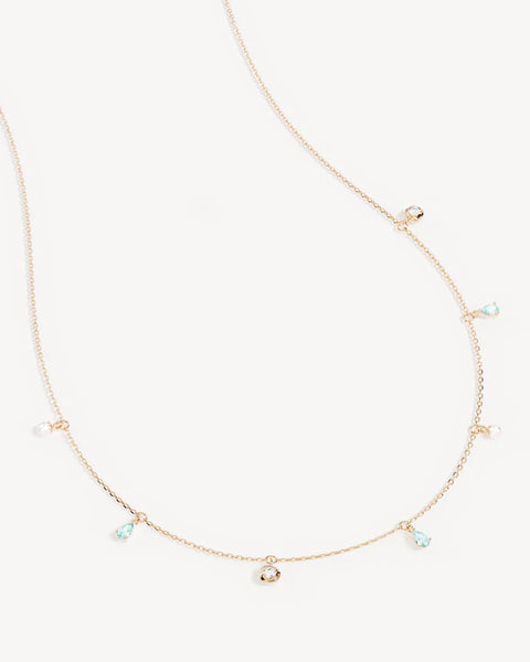 A full studio product photograph displaying the 18k Gold Plated Breathe In Stillness Choker arranged in a wide arc against a clean white background, showcasing the repeating sequence of delicate charms fixed 3cm apart along the fine chain, including bezel-set cubic zirconias and teardrop mint green tourmaline nano gemstones.