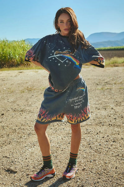 A full-length studio product shot from the front on a model wearing the very oversized vintage black graphic tee, demonstrating its relaxed drape, spacious dropped shoulders, and how it can be styled effortlessly as a casual t-shirt dress.