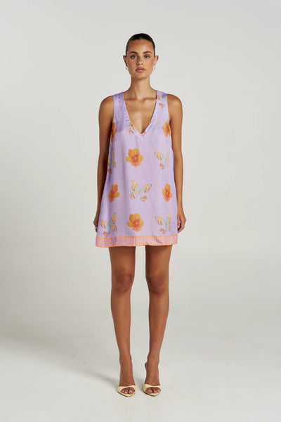 Front studio shot of a model wearing the Summi Summi V Shift Dress in Reverie, a lilac mini dress featuring a deep V-neckline, floral and butterfly print, and patterned hem.