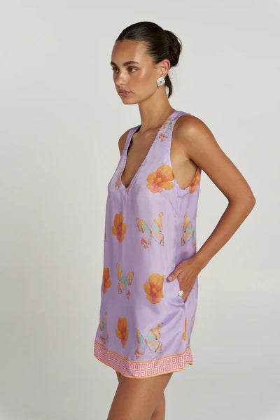 Close-up side profile of a model posing in the Summi Summi V Shift Dress in Reverie, highlighting the side pocket and soft lavender butterfly print.