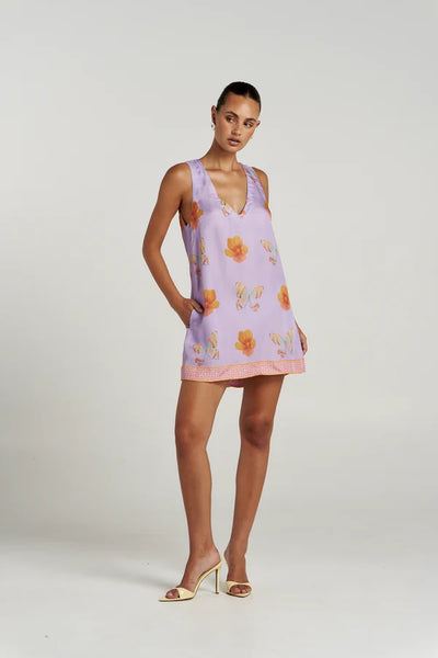 Full-body view of a model with hand in pocket wearing the Summi Summi V Shift Dress in Reverie print, styled for summer.
