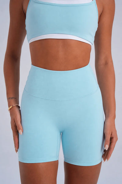 Close-up studio front shot of the high-rise seamless tapered waistband and front panel construction of ice blue buttery-soft bike shorts.