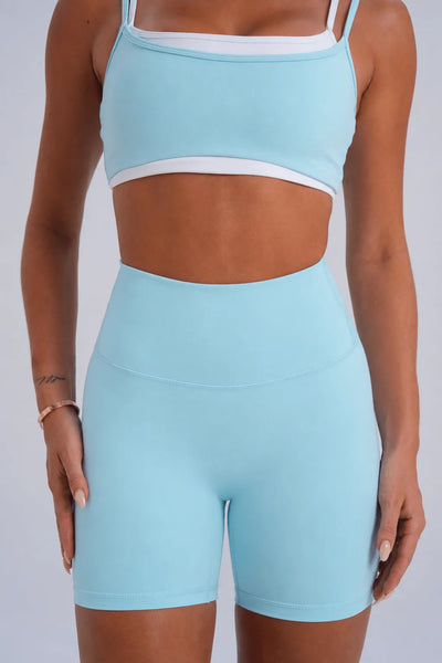 Front mid-section studio shot highlighting the smooth, seam-free front rise and high waistband of ice blue activewear bike shorts.