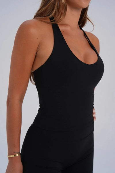 Close-up studio side view of a model wearing a black buttery-soft Nylon/Spandex racerback tank top.