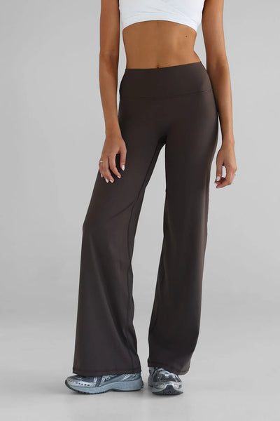 A front angled studio shot from the waist down of the LEELO Tall Sculpt Wide Leg Pants in dark chocolate. The description captures the seamless tapered high waistband designed for tummy control, a smooth no-front-seam construction, and a fluid, wide-leg silhouette.