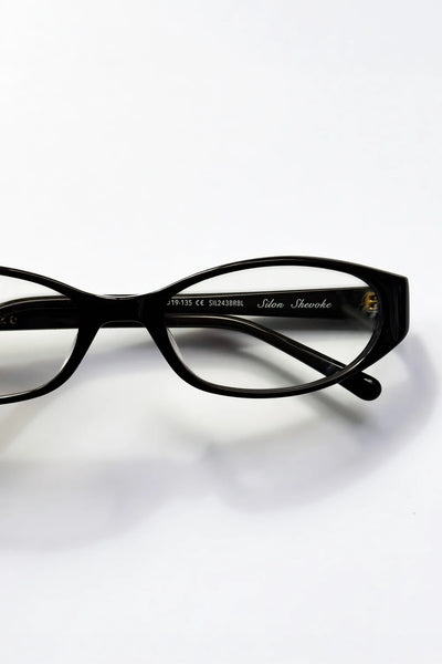 Close-up view of the inner arm of the SHEVOKE Silon black frame, displaying the cursive white "Silon Shevoke" logo and style code stamp.