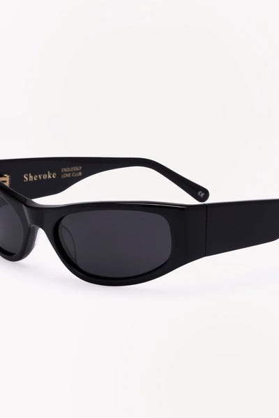 Close-up side profile of the sunglasses highlighting the shiny black acetate frame and gold "Shevoke Endlessly Love Club" inner temple branding.