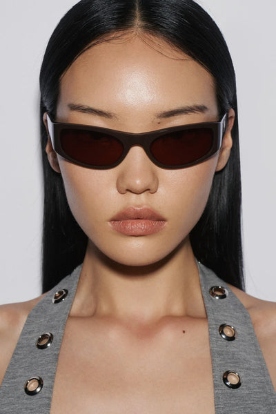 Direct front portrait of a model wearing the SHEVOKE Jen 002 solid brown acetate wrap sunglasses with a 20-degree bending lens profile.