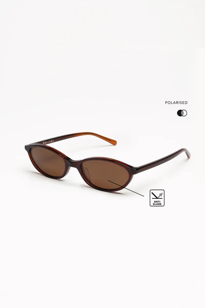 Three-quarter side angle shot of crystal brown oval sunglasses with a small "Anti Glare" badge overlay and "Polarised" icon graphic highlighting the polarised lens feature